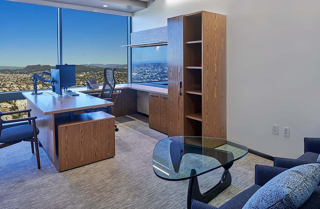 A private office with guest chairs, a glass coffee table, and soft seating.