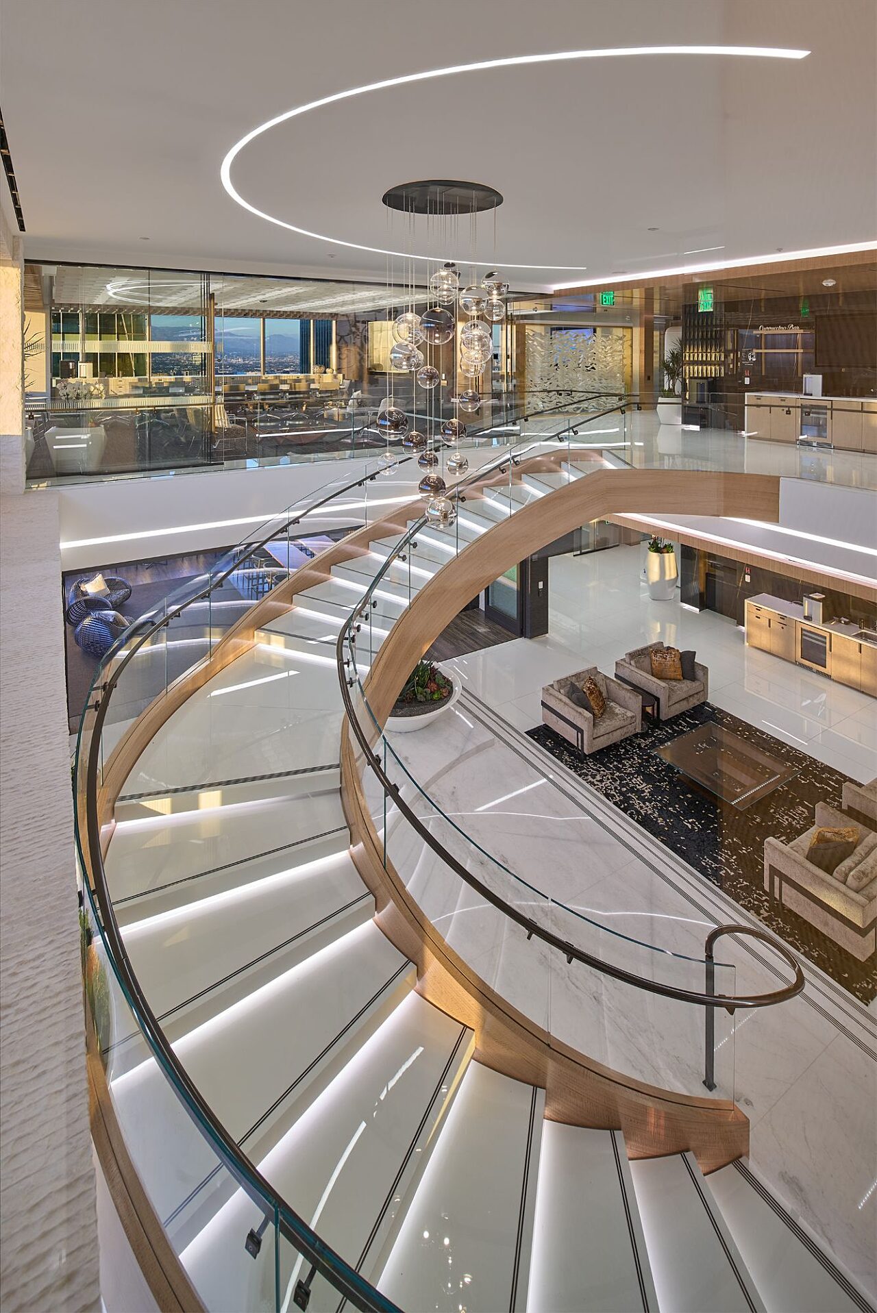 Curved staircase overlooking lounge seating and gathering spaces at Paul Hastings.