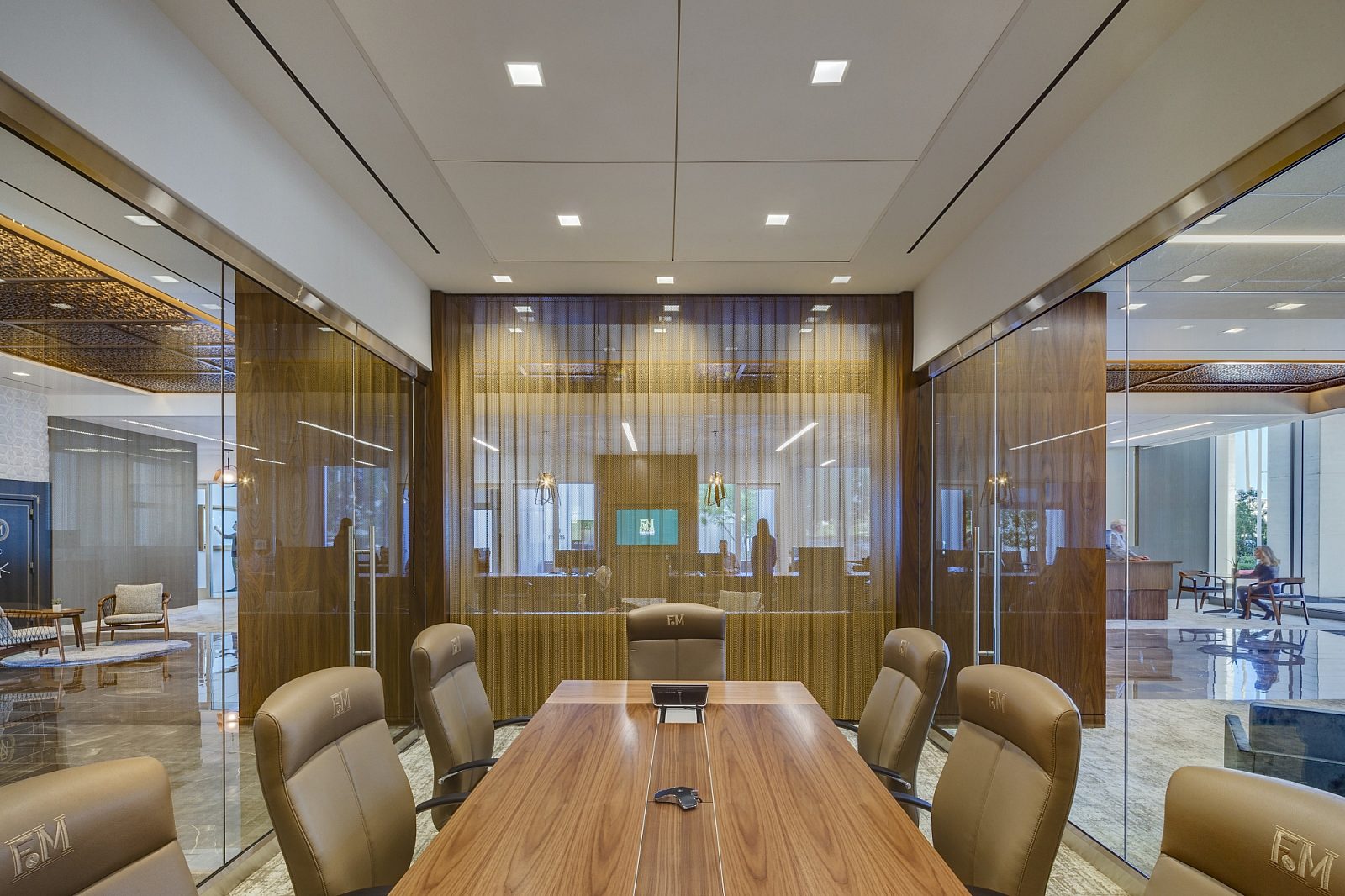 In a conference room, there's a wooden conference table and leather desk chairs.