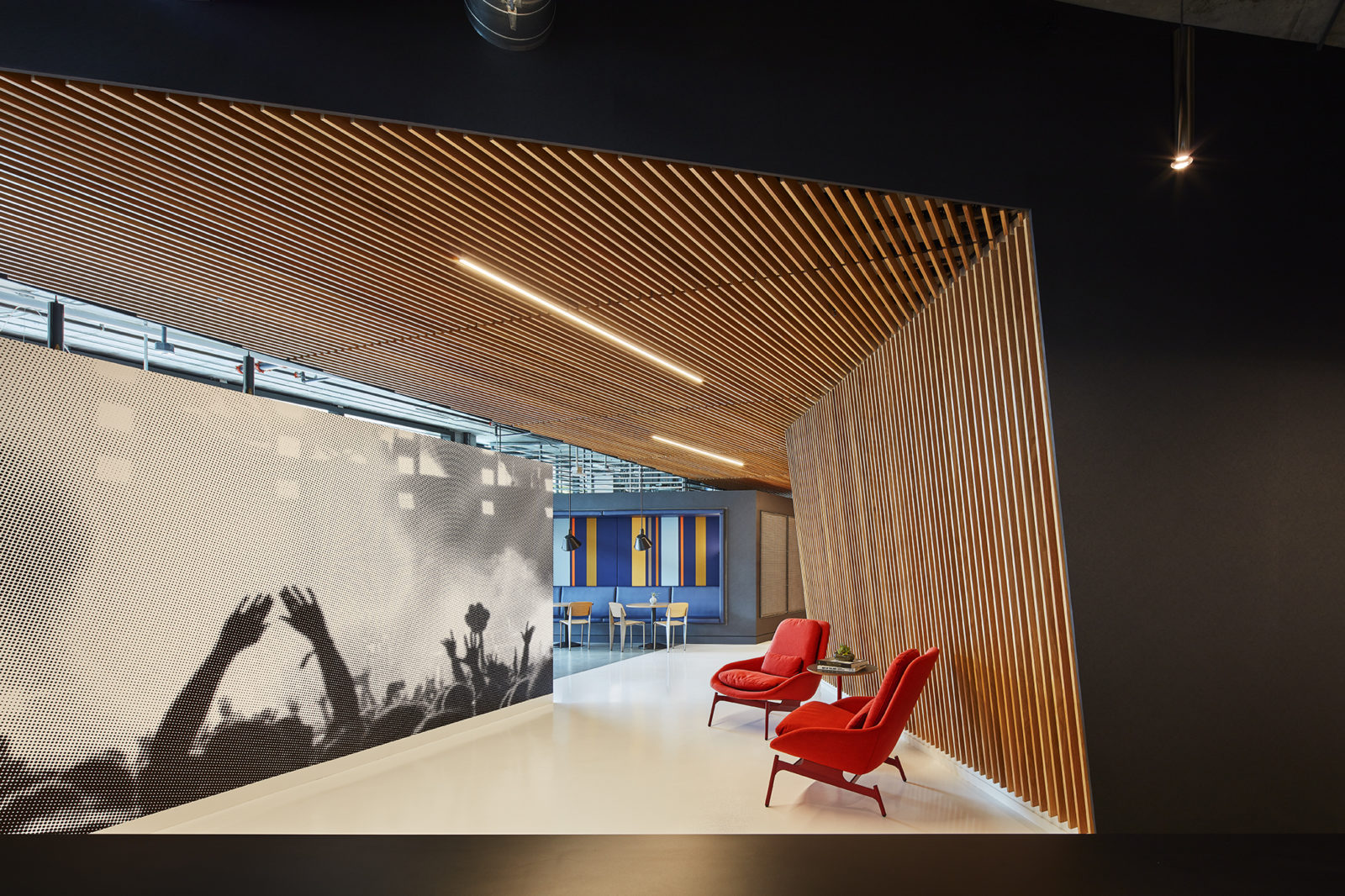 A hallway with two red lounge chair placed at the right side of the area.