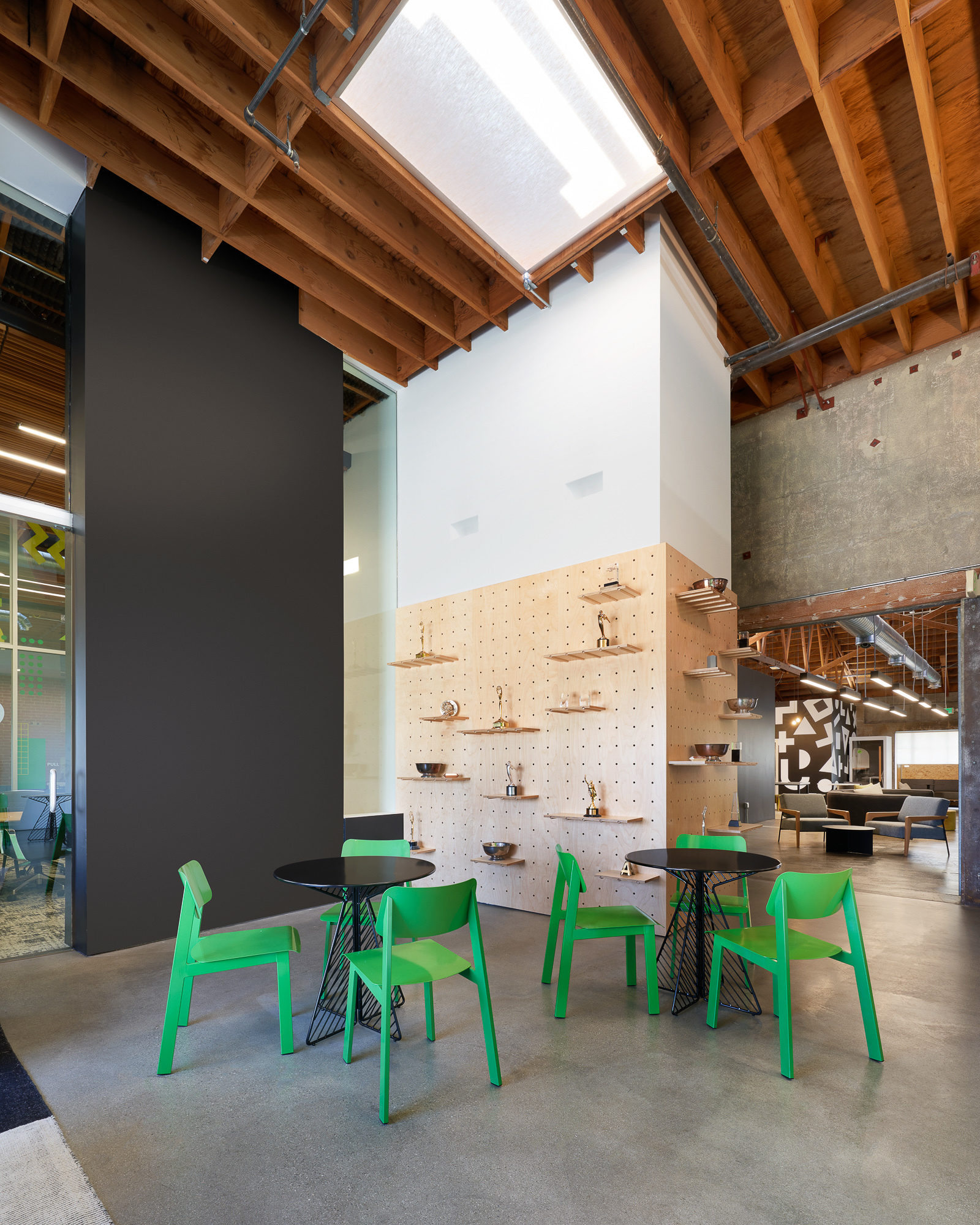 An office area featuring neon light green banquettes and black coffee tables