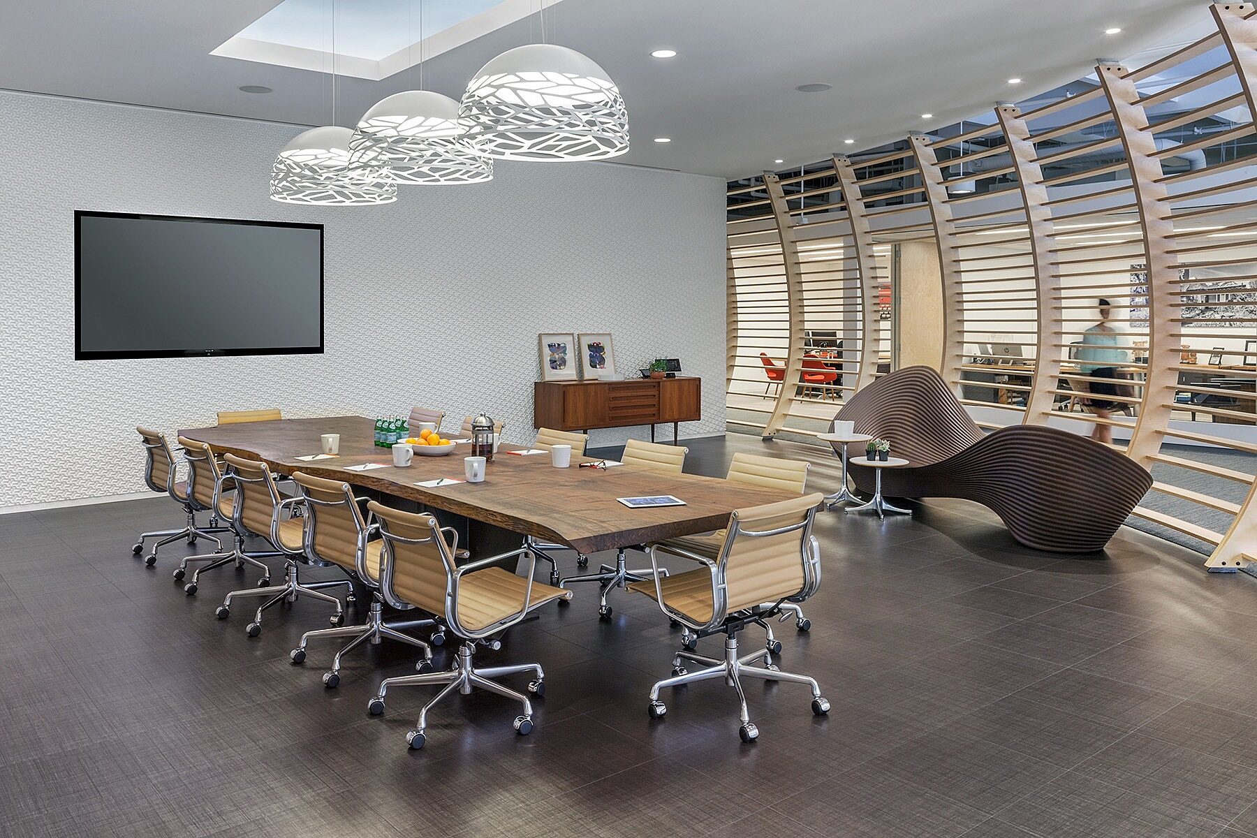 A private conference room with a wooden desk and few office chairs.