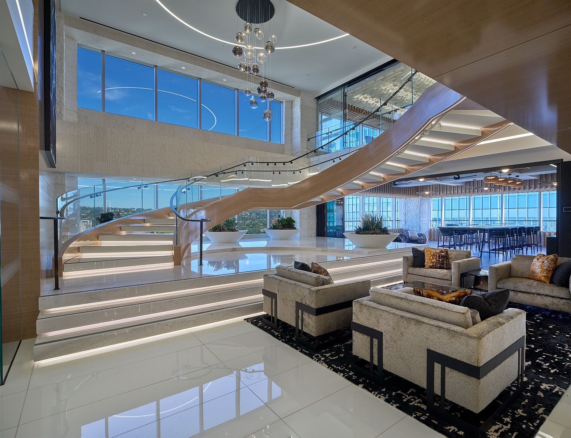 Curved staircase overlooking lounge seating and gathering spaces at Paul Hastings.