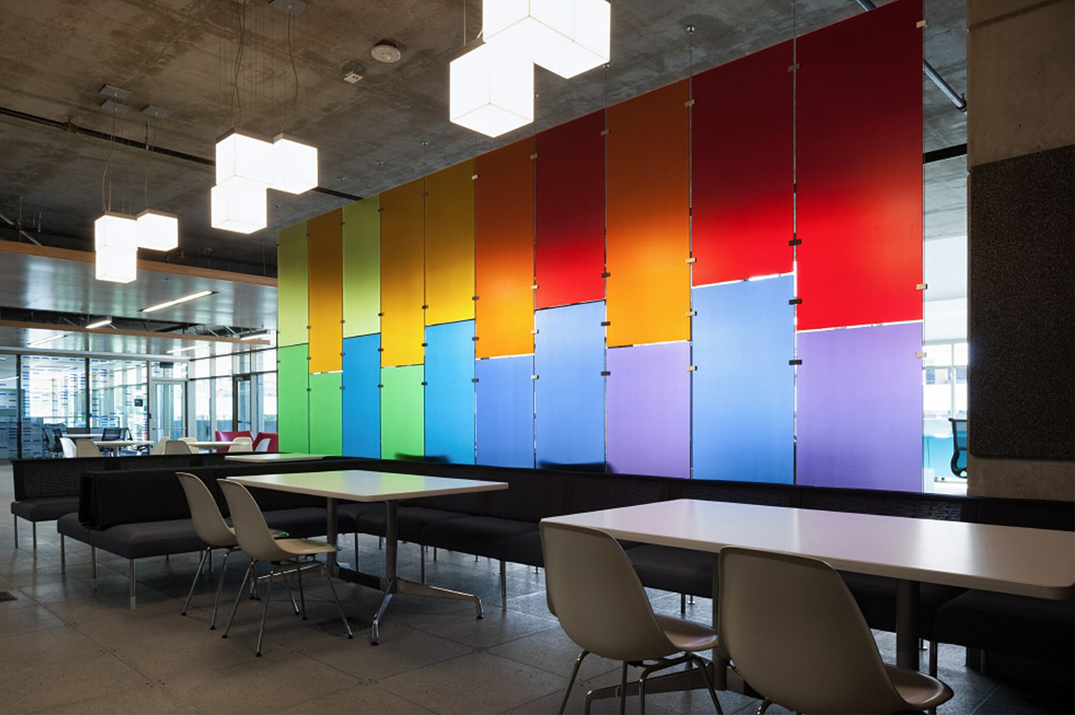 A vibrant and inviting workspace with a colorful accent wall complemented by a few office chairs and desks, creating a lively and energizing atmosphere.