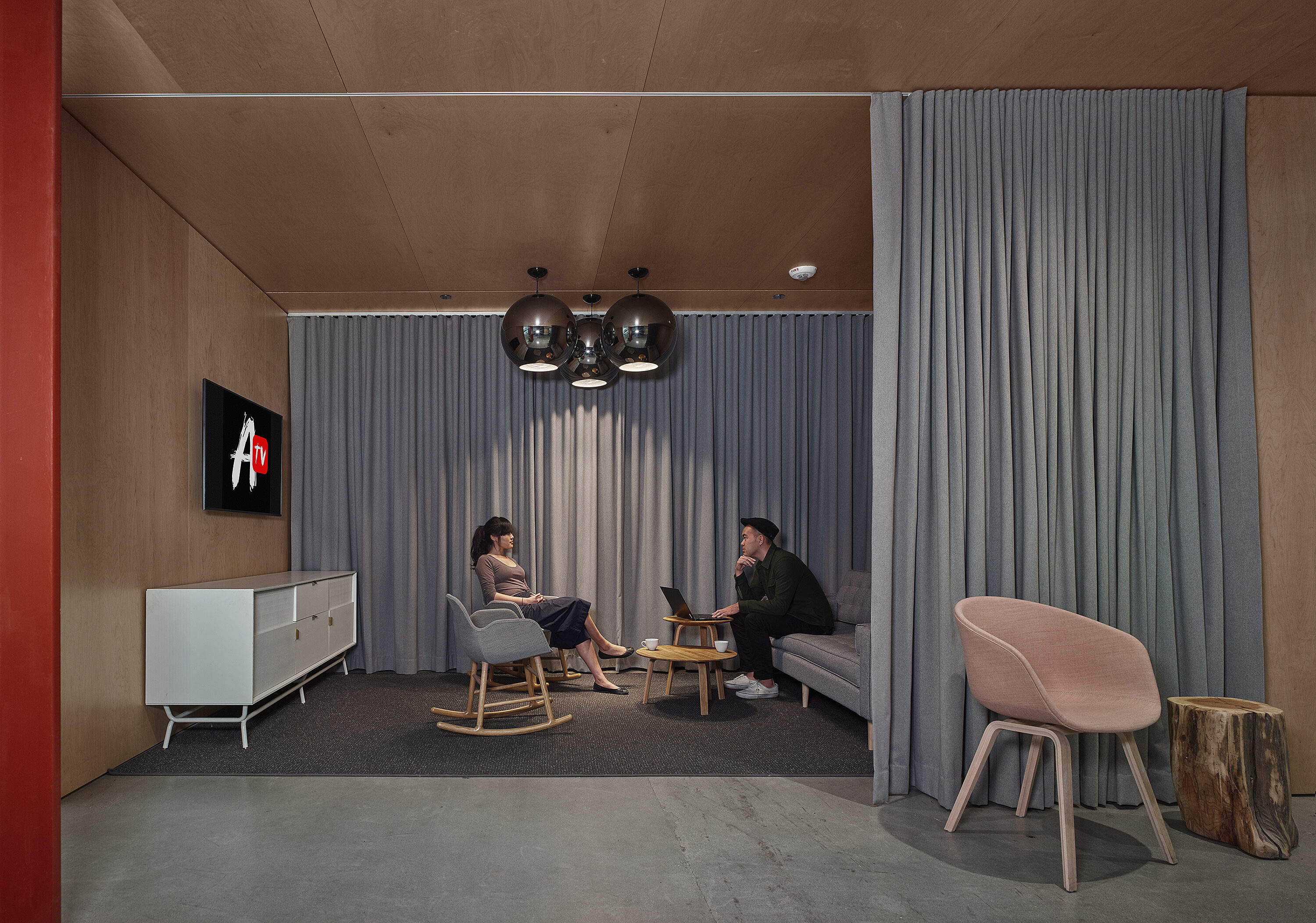A lounge chair area with a television on the wall.