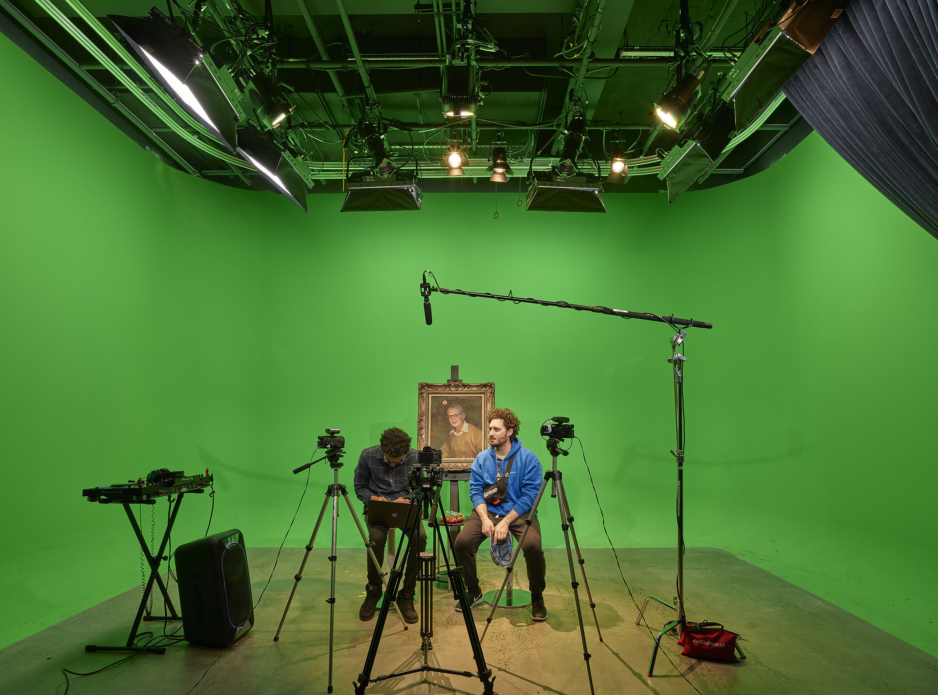 A recording room with two man seating on the stools .