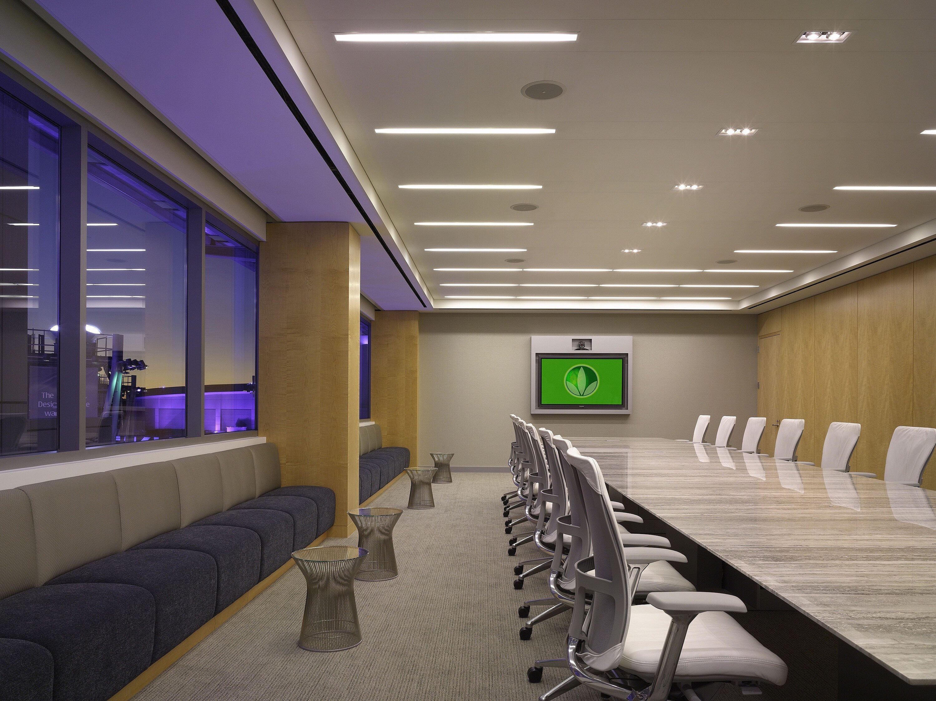 A private conference room with a long marble table and multiple office chairs.