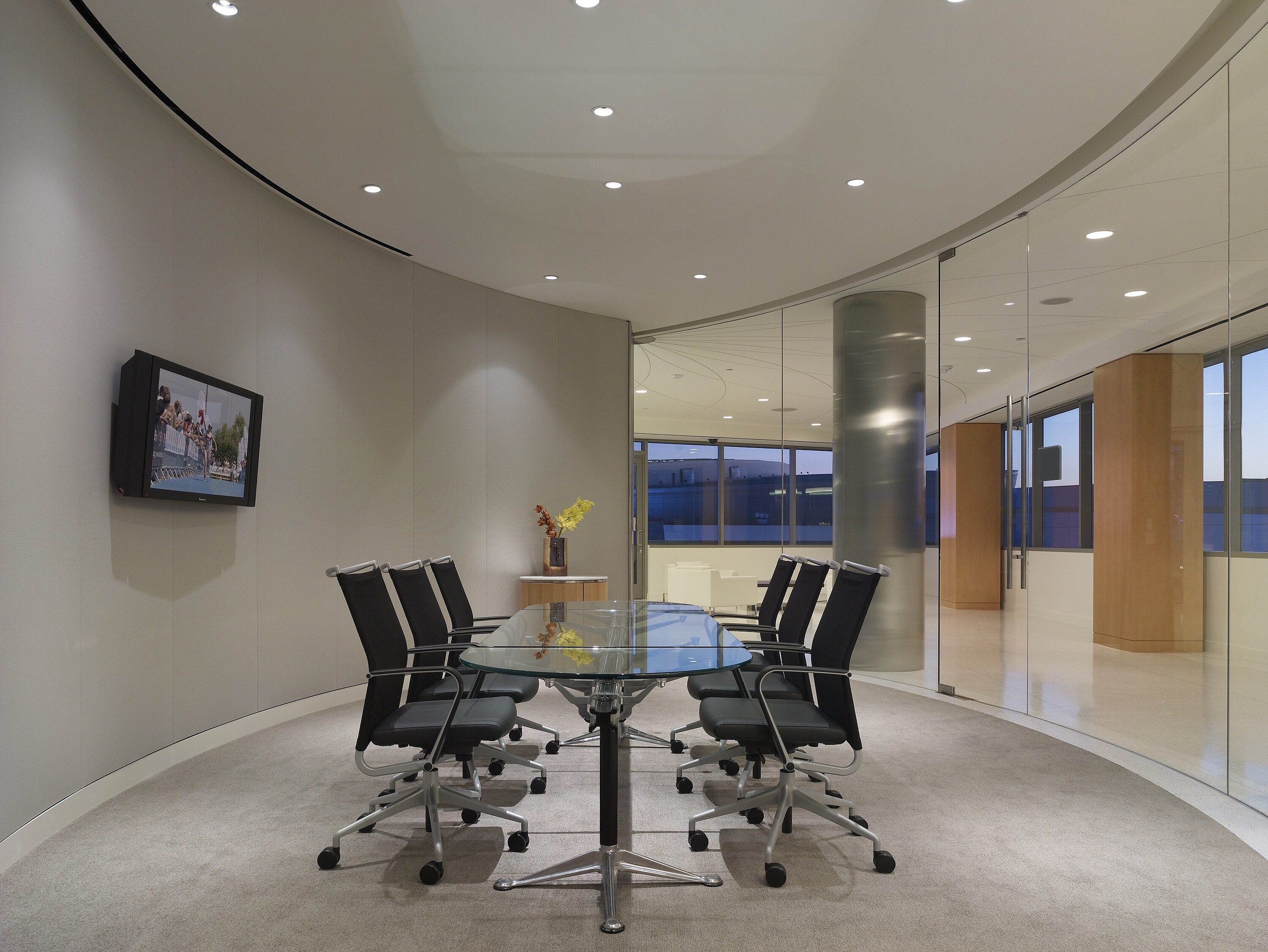 Private room with round sofa, black lounge chairs, and white coffee table, creating a stylish and inviting seating arrangement.