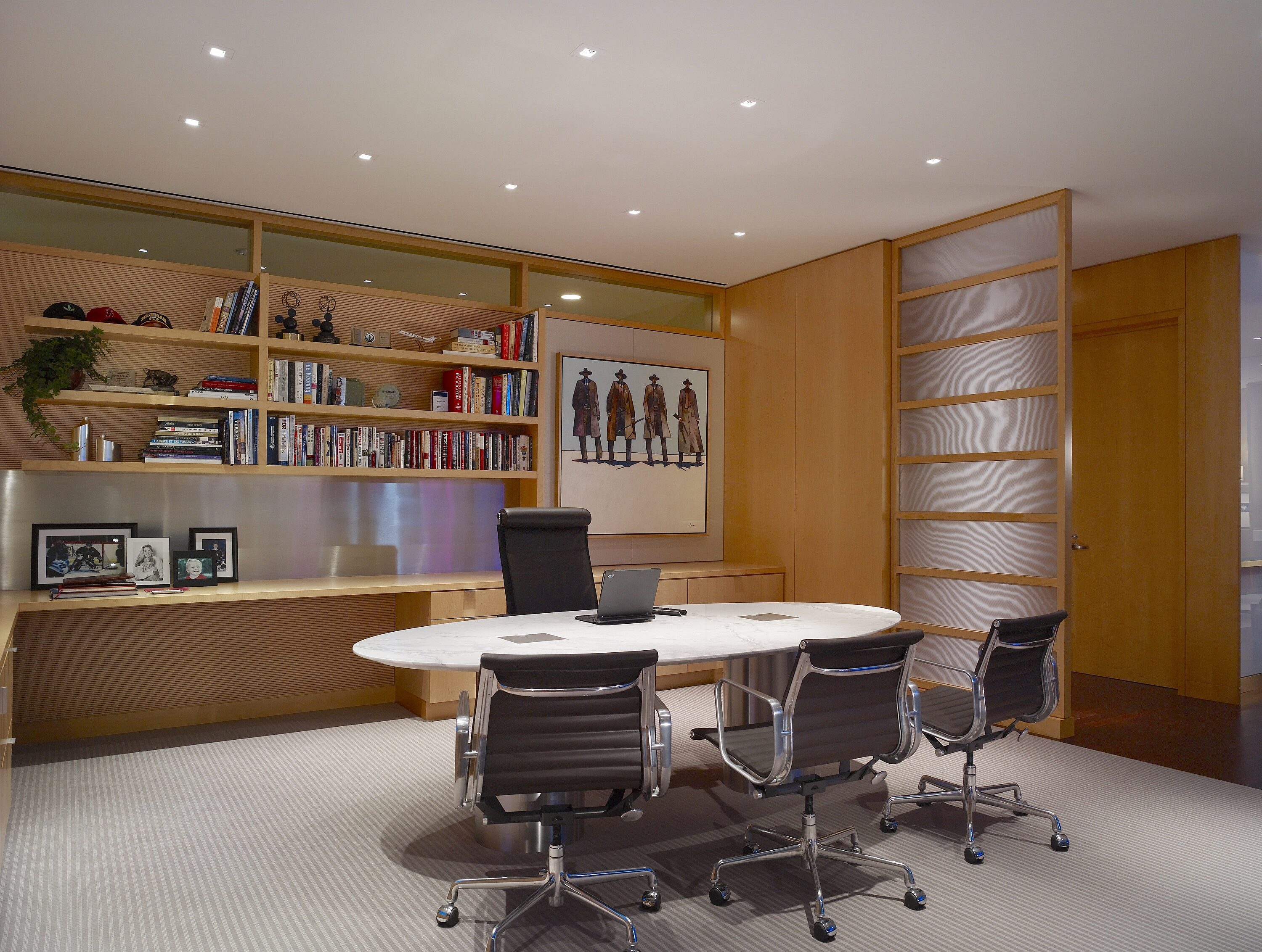 A large executive desk and comfy seats dominate the private office. A lovely oak bookcase on the rear wall adds warmth and refinement.