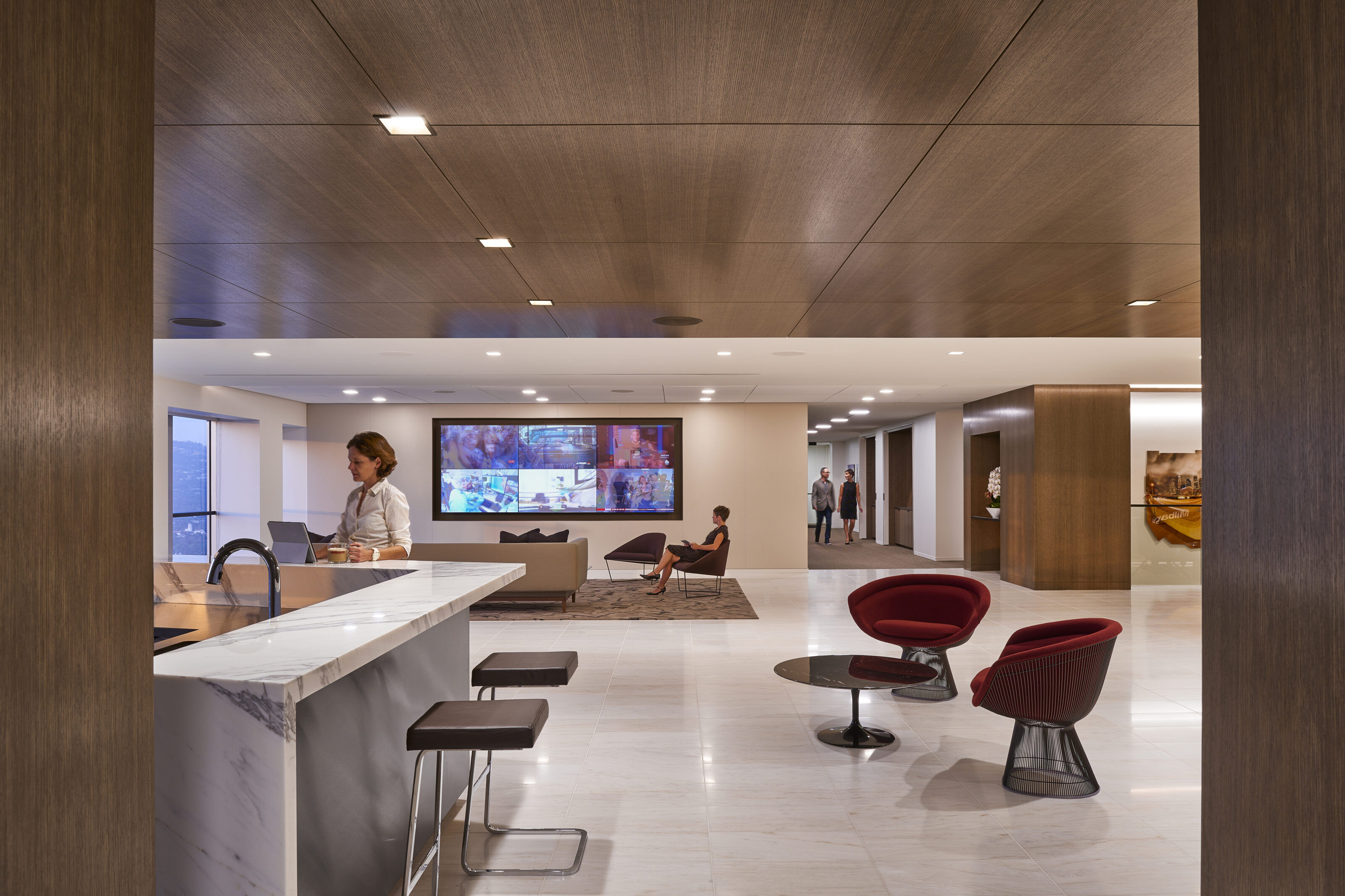 At the corner of the room, a marble bar table adorned with uniquely designed stools stands as an elegant and eye-catching addition
