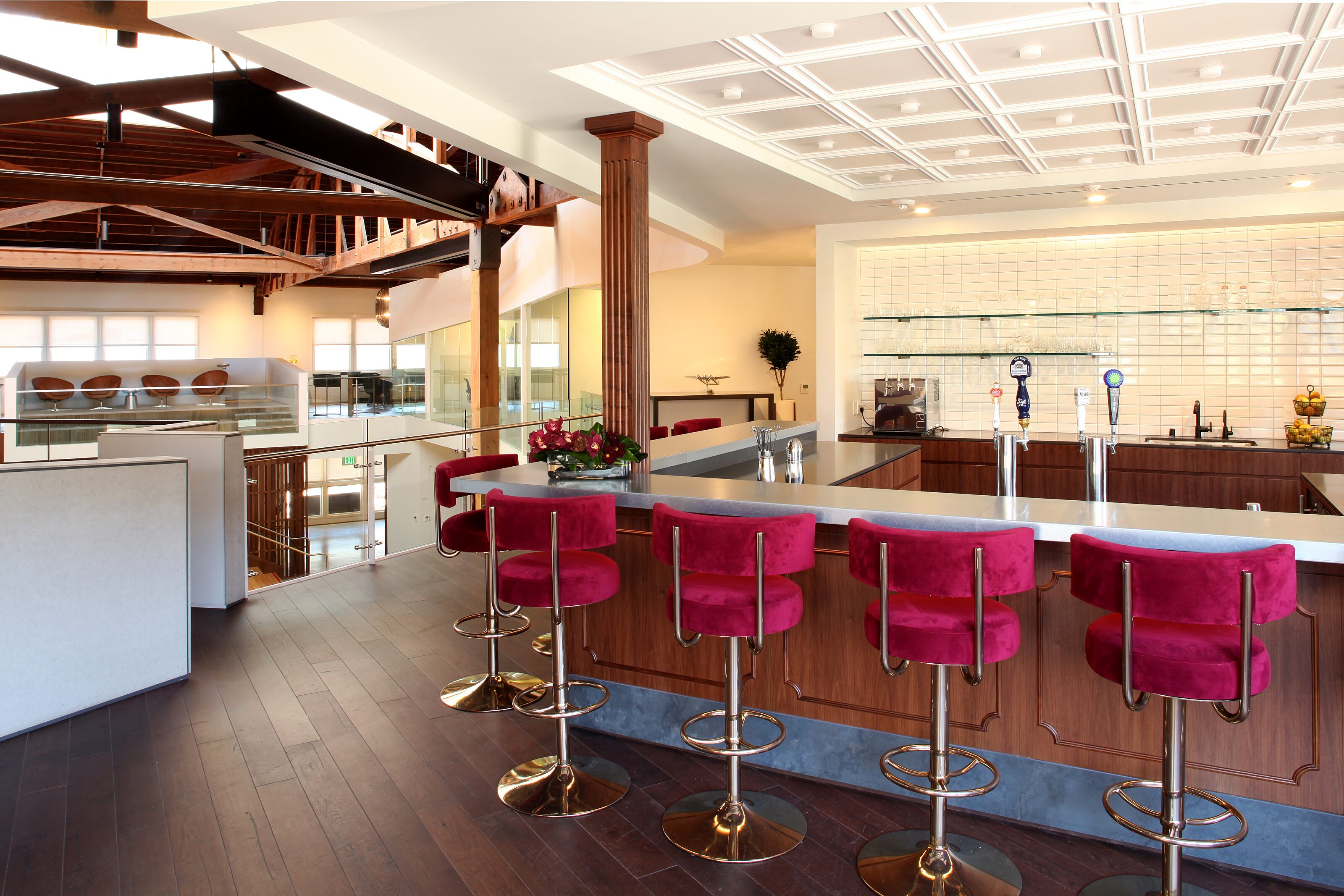 A large space with bar-top and high-top pink chairs.