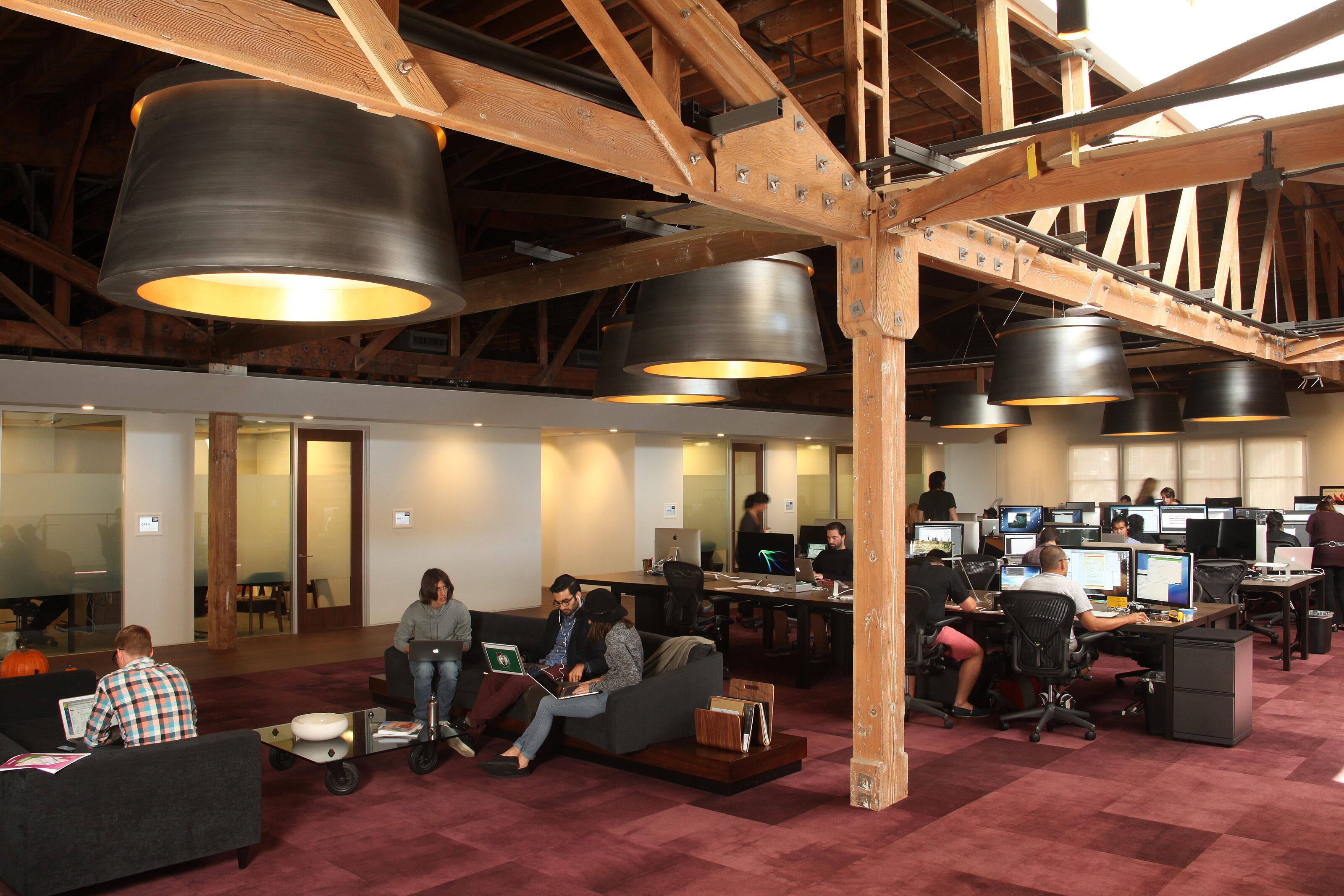 Open office space with workstations and a lounge chair area, accommodating diverse group sizes for productivity and relaxation.