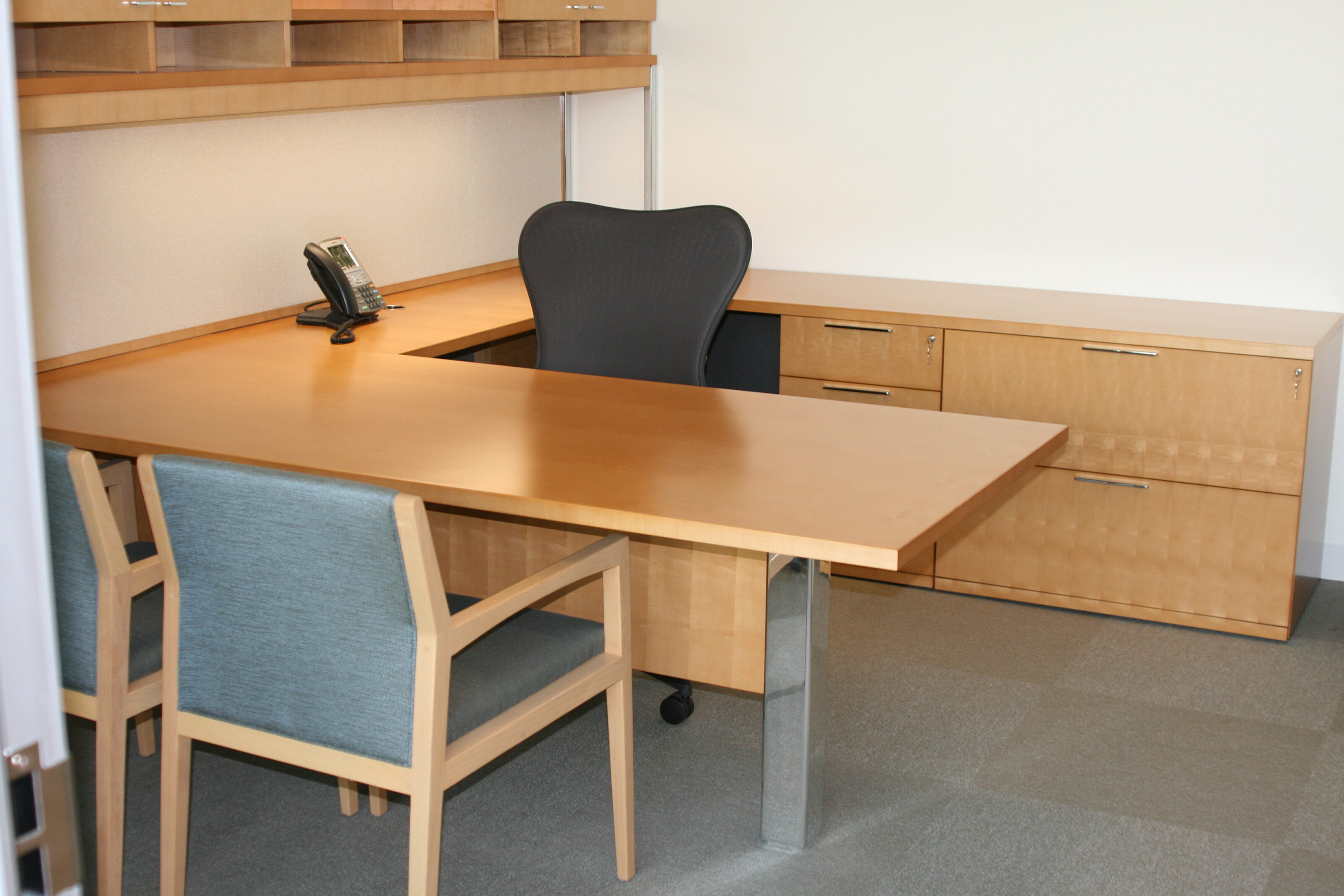 A private place with one wooden guest cafe chair and a black office chair.