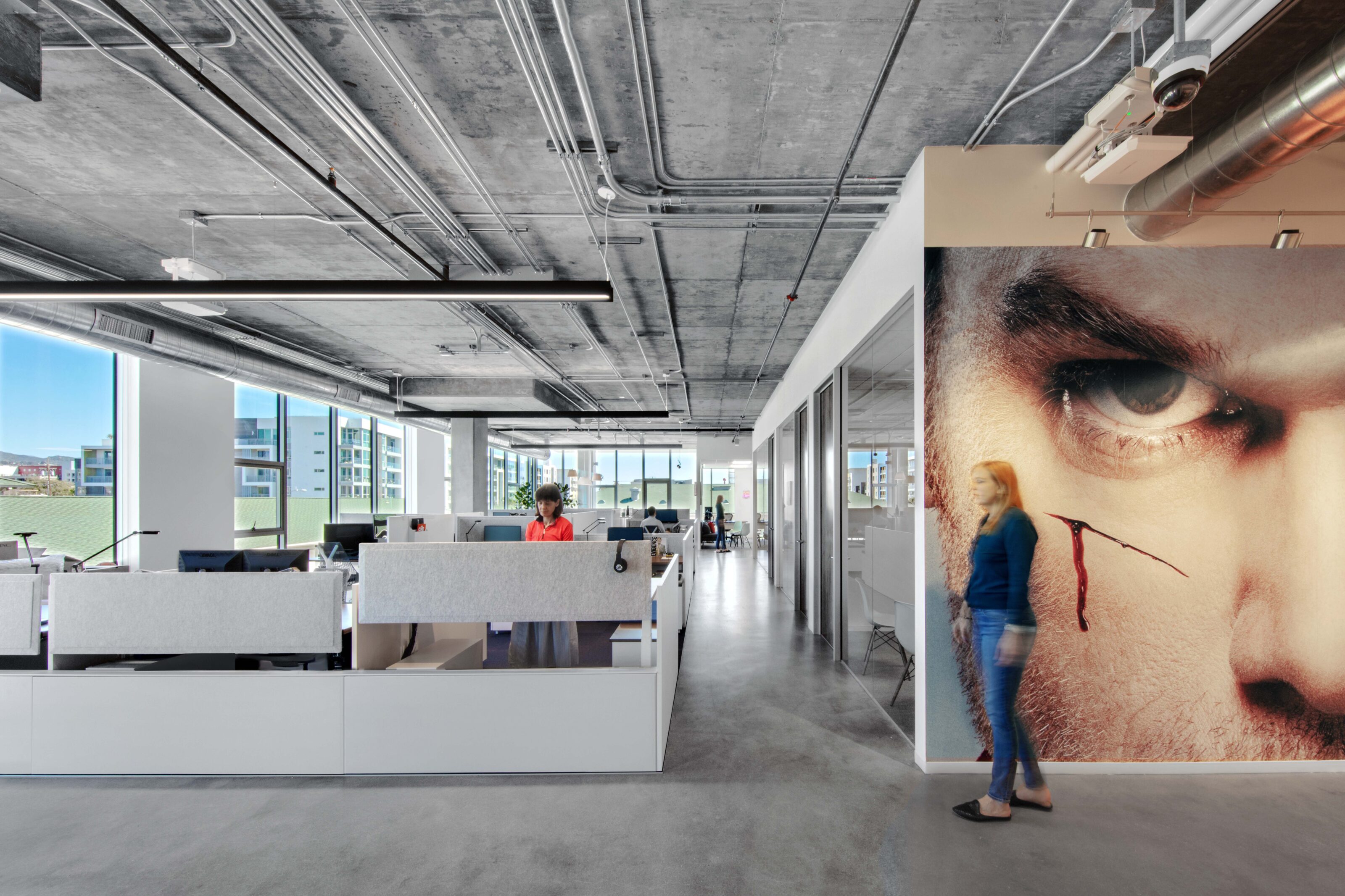 The walkway separates the working stations from the private conference room while retaining a unified design.