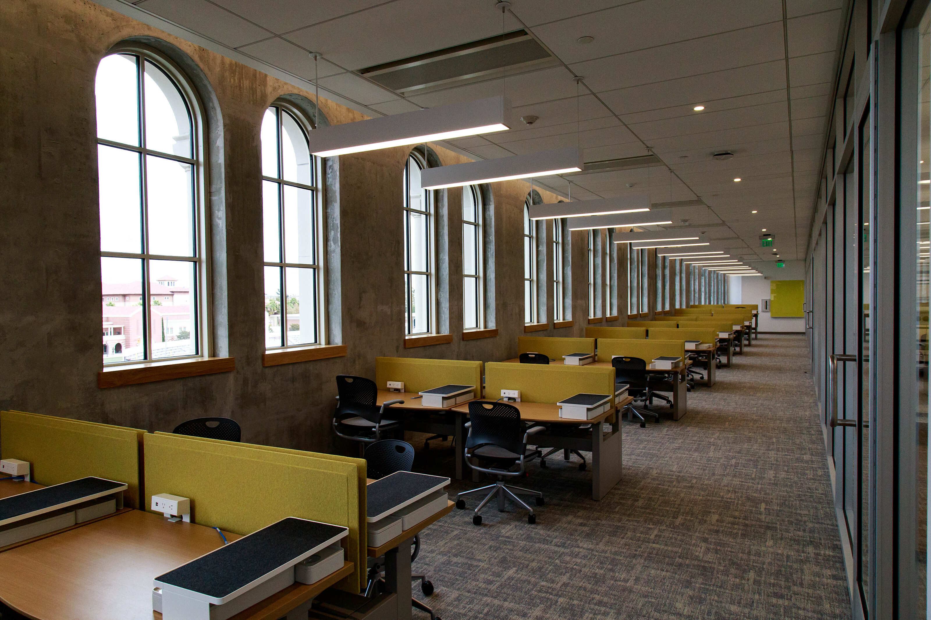 A bright and warm screen room featuring a row of wooden conference tables and folding chairs for productive meetings and discussions.
