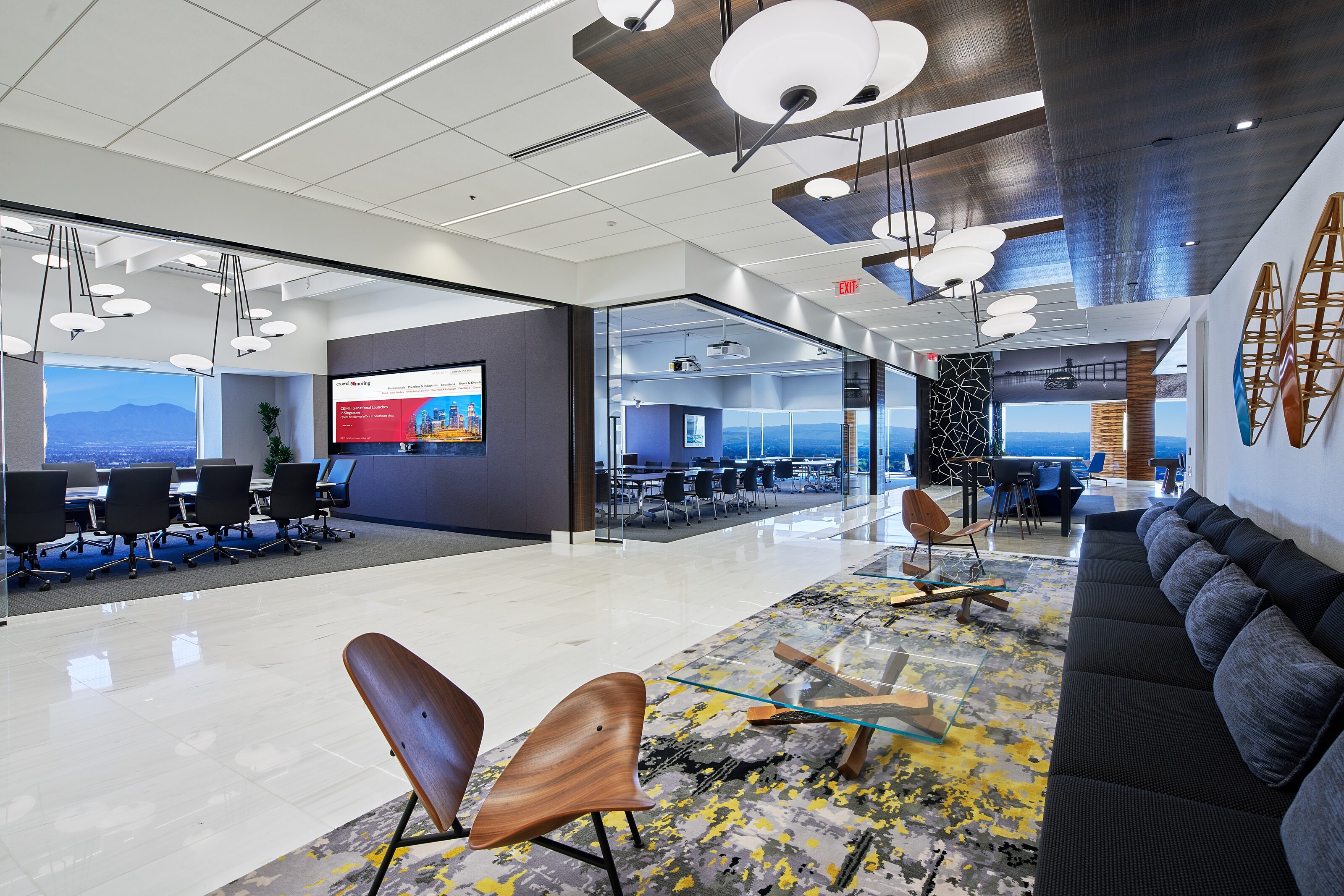 A colorful carpet with blue color booths and the wooden lounge chairs.