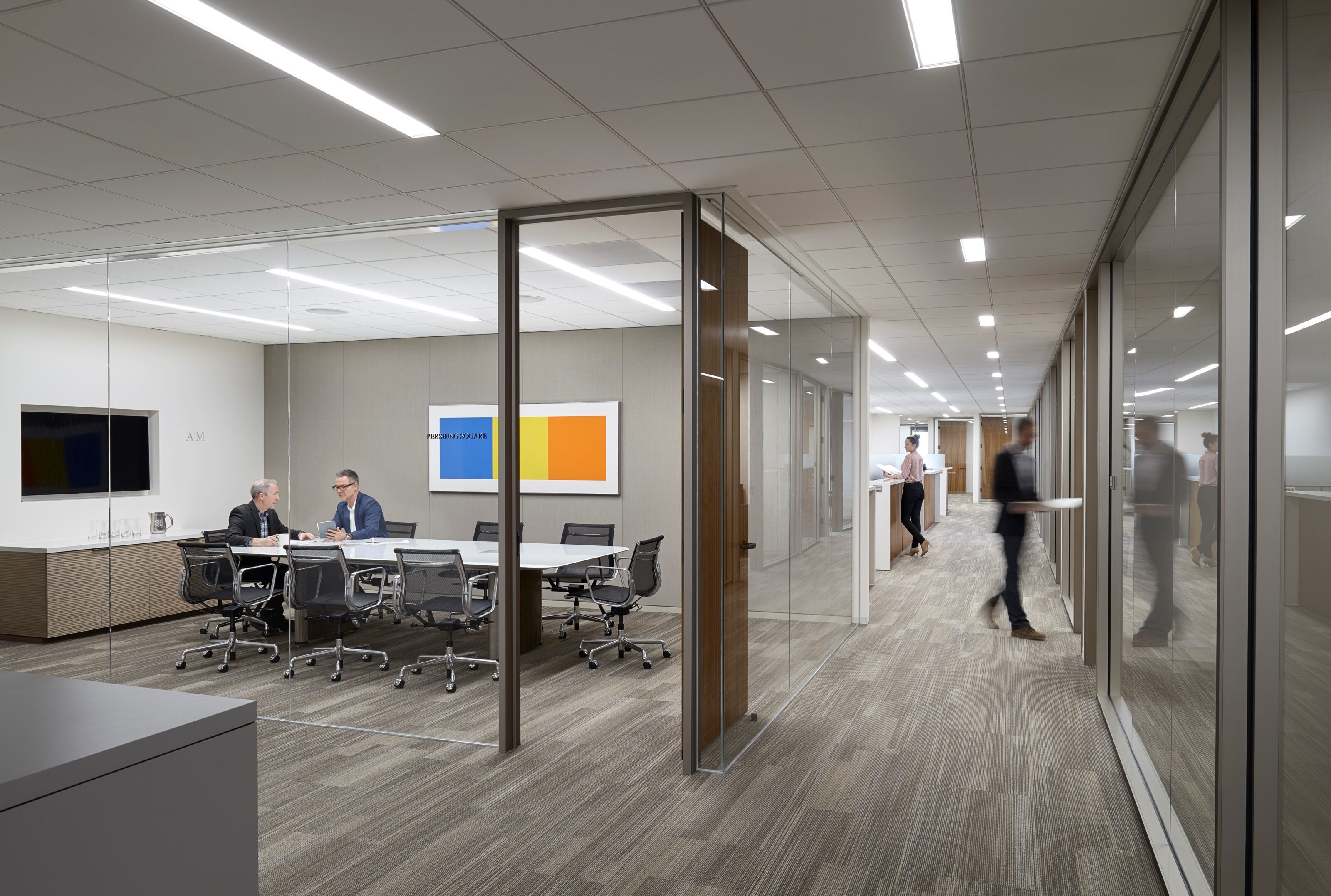 A conference room with many office chairs and one white conference table.