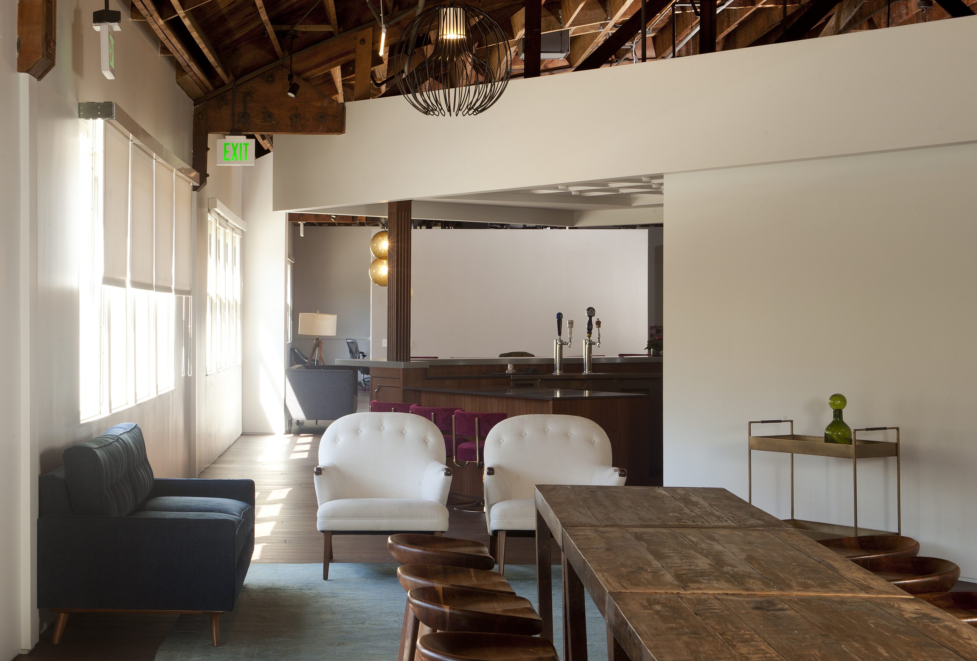 A vintage-inspired workspace with a charming wooden desk and a collection of cozy lounge chairs, creating a nostalgic and inviting atmosphere.