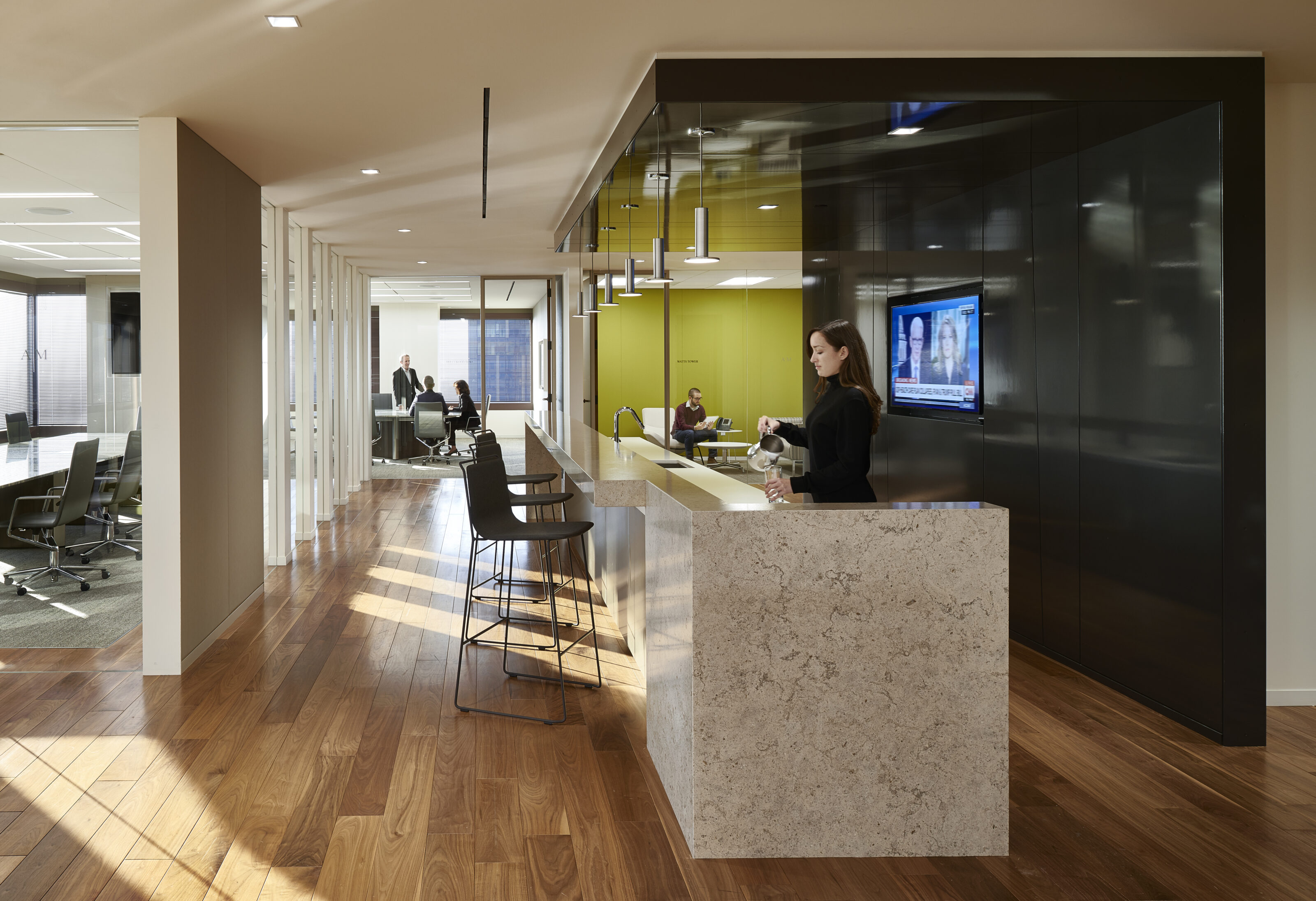 A reception area with a lady standing in front of the reception desk.