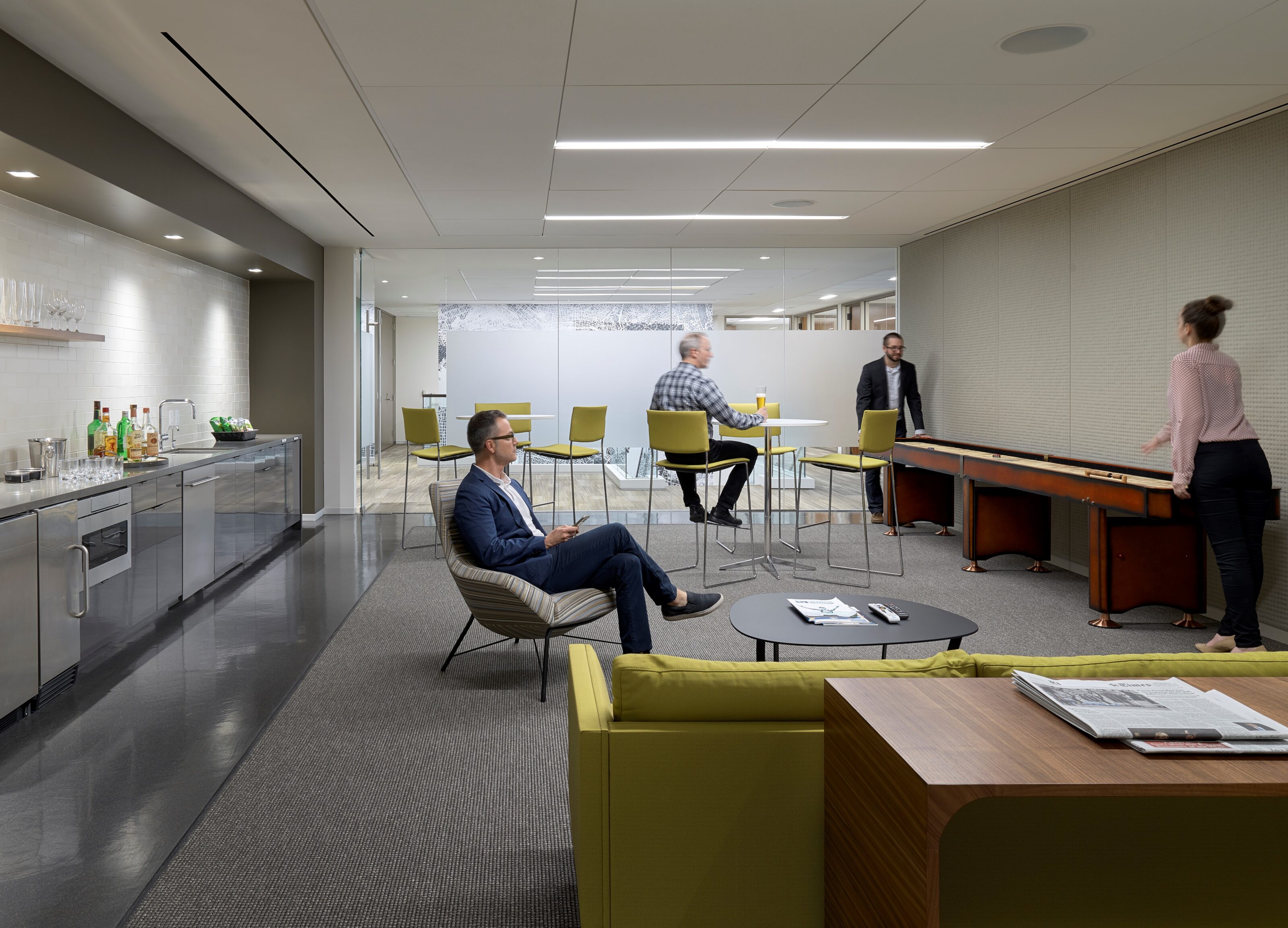 A conference room with lounge chairs and stools.