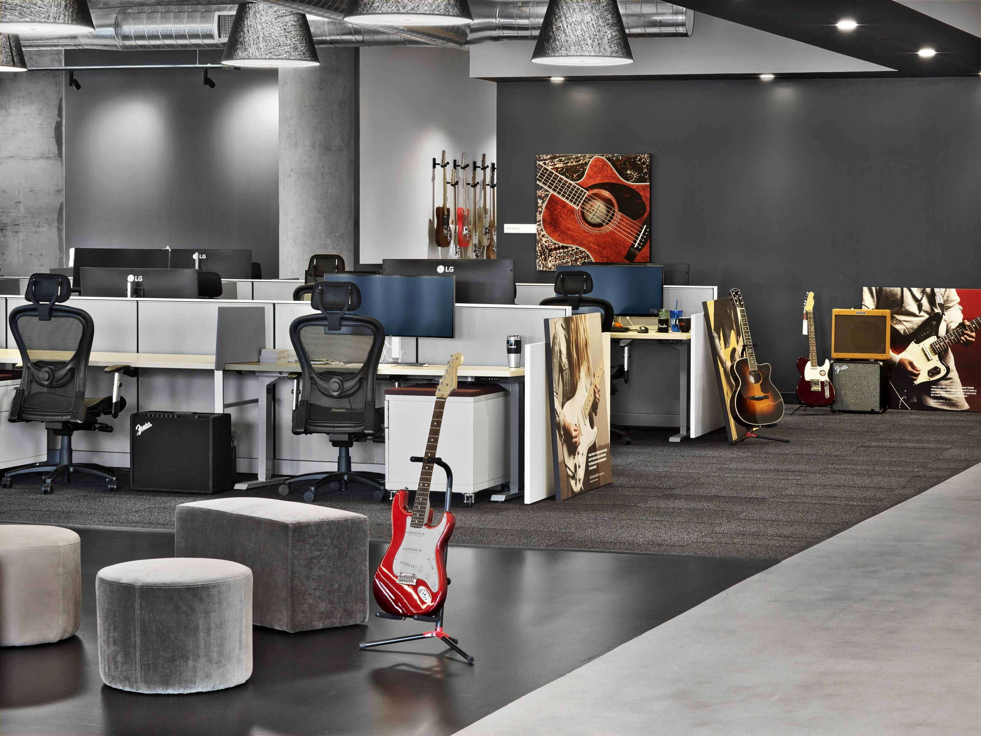 Open office with working stations and multiple guitars.
