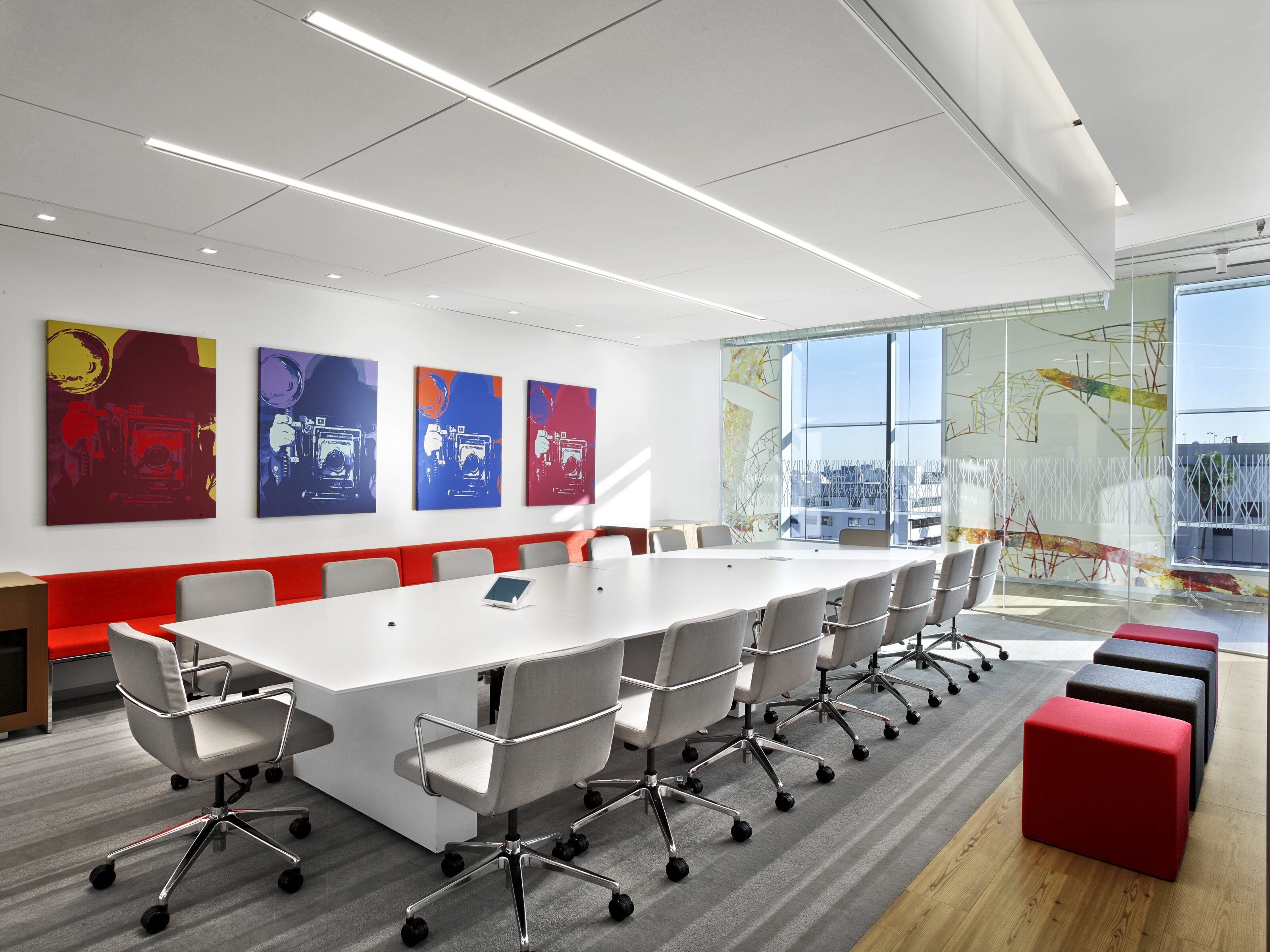 A private conference room with a large white conference table and lots of office chairs.