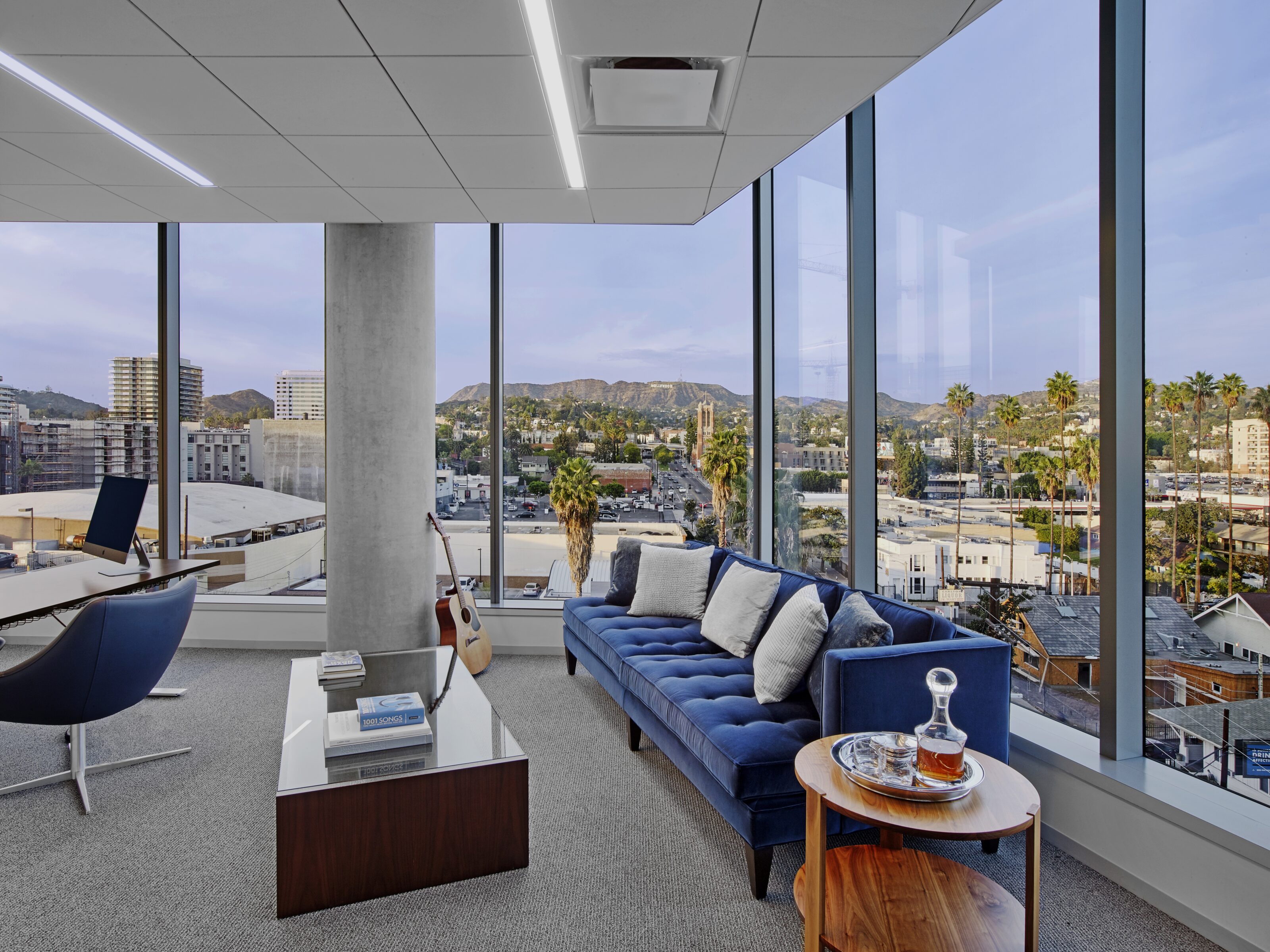 A cozy blue sofa positioned in front of a picturesque window view, adding a touch of relaxation and serenity to the office space.