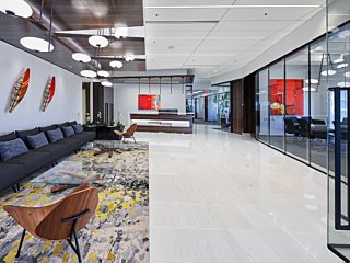 A OPEN AREA WITH BLACK LOUNGE CHAIR ON A ARTISTIC CARPET.