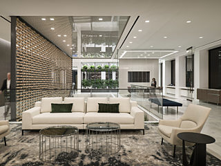 A waiting area with white sofa and few lounge chairs.