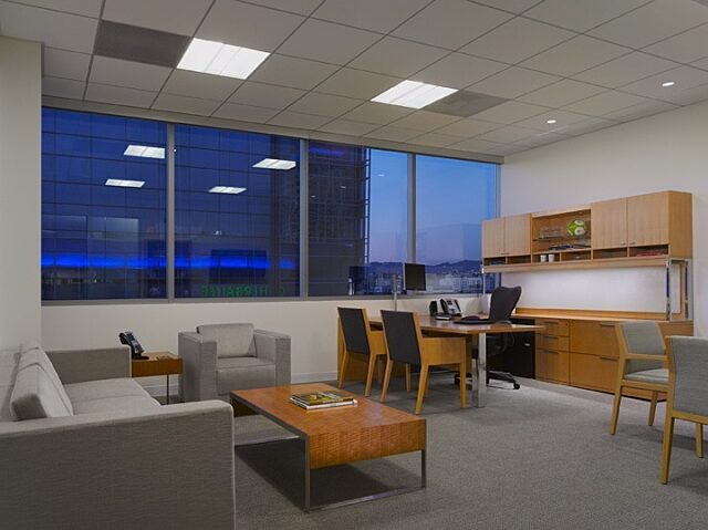 A comfortable lounge chair area with a wooden desk neatly placed next to it.