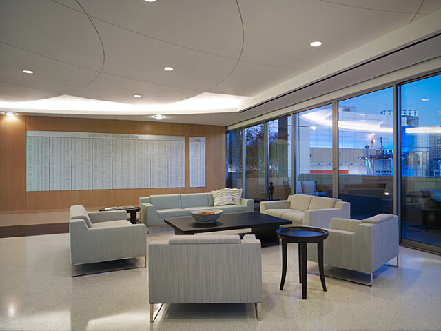 A comfortable seating area with lounge chairs, next to which is a traditional desk made of wood.