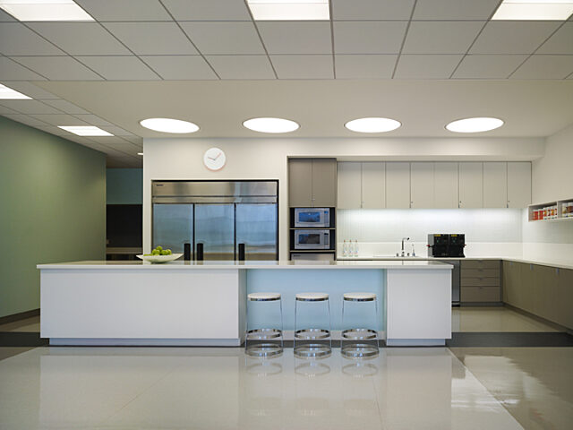 A centrally positioned bar table with three accompanying stools, creating a focal point in the room for socializing and enjoying drinks.