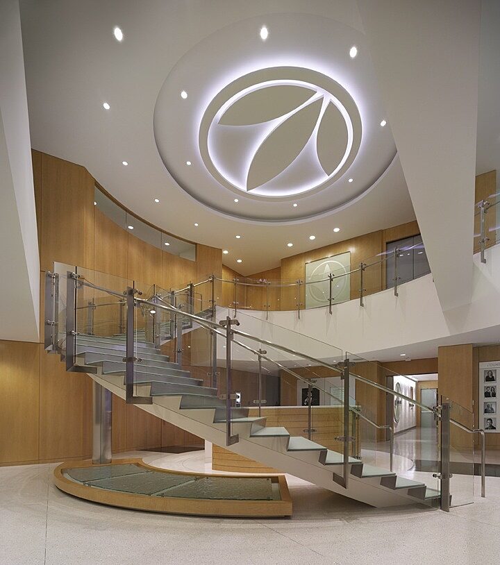 Inviting lobby featuring a central staircase, bathed in warm light, radiating a cozy and welcoming ambiance.