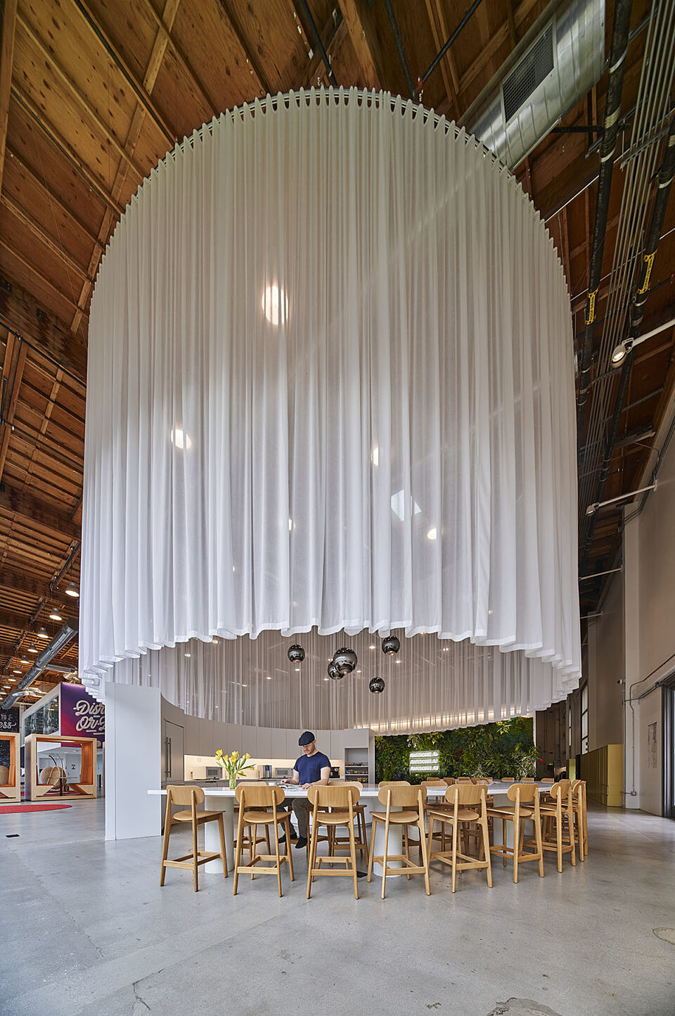 A circular bar table with several wooden chairs creates a pleasant, welcoming environment for beverages, talks, and a lively atmosphere.