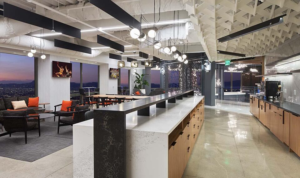 A break area with a bar top kitchen area and seating areas behind it.