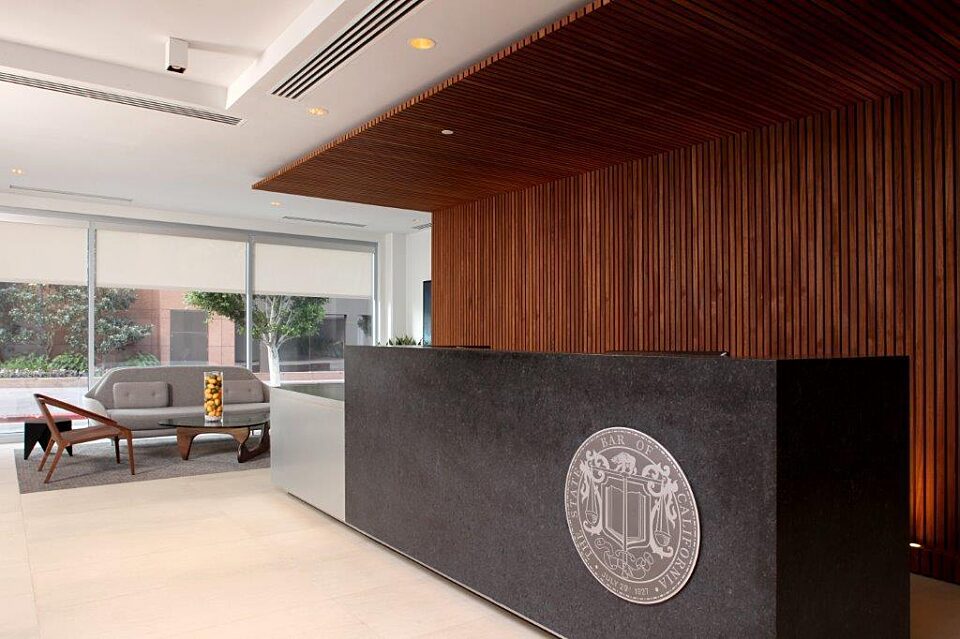 A sleek black reception desk positioned in front of a wooden wall.