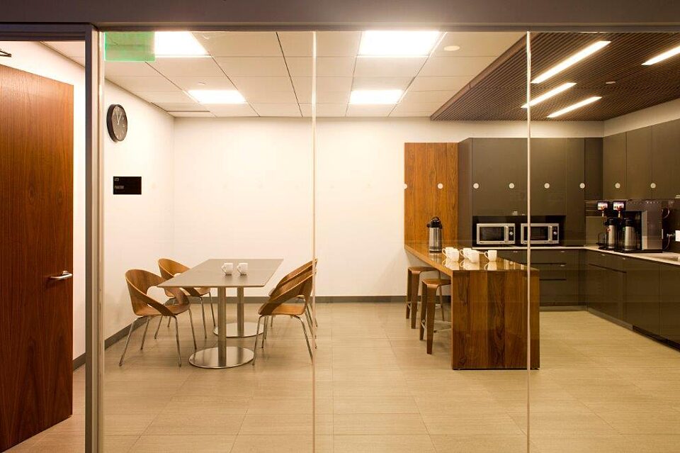 A comfortable and adaptable break room with café chairs and desks. A high bar table with stools provides casual seating.