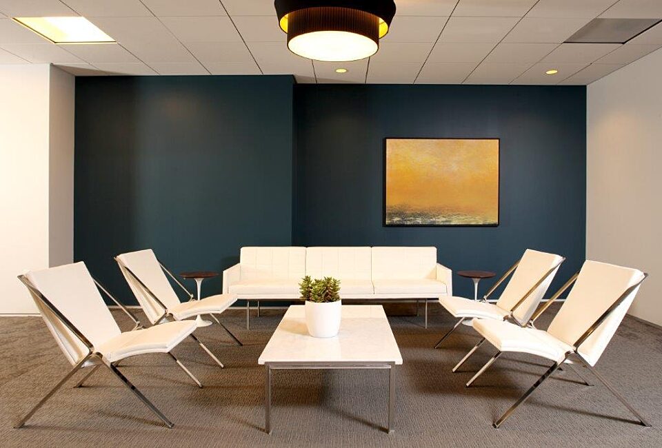 A huge open area with a white third-person sofa, coffee table, and four lounge chairs.